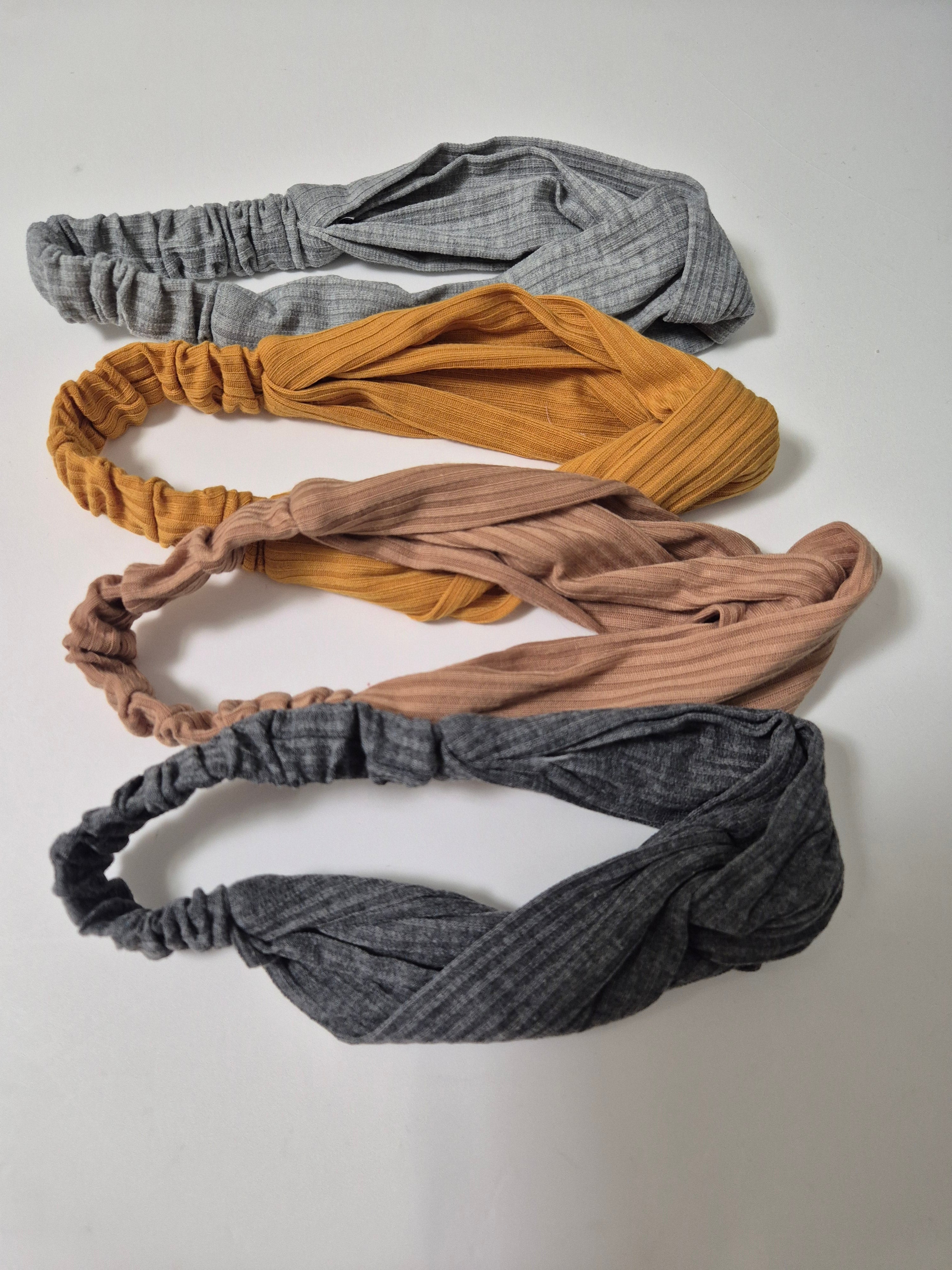 Kavya 4 pack of wide, soft elastic hair headbands for women, shown in black and neutral tones on a model.